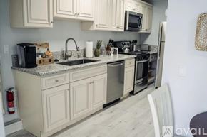 North Hollywood house for rent - A kitchen with white cabinets and a granite countertop.