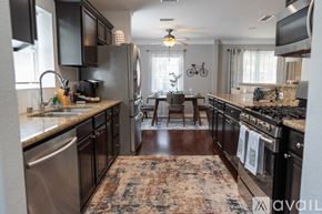 North Hollywood house for rent - A kitchen with black cabinets and a rug on the floor.