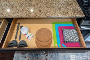 North Hollywood house for rent - A drawer with a cork coaster, a pair of tongs, a spatula, and a pot holder.