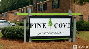 Hinesville apartment for rent - A sign for Pine Cove Apartment Homes is displayed in front of a brick building.