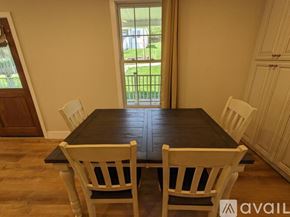 Asheville apartment for rent - A dining room with a black table and white chairs.