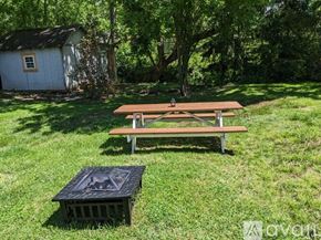 Asheville apartment for rent - A picnic table and crate are on a grassy lawn.
