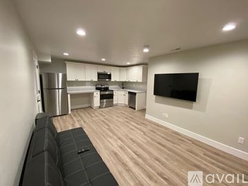 Lehi apartment for rent - A modern living room with a grey sofa and a flat screen TV mounted on the wall.
