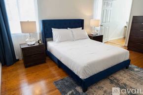 Fullerton house for rent - A bedroom with a large bed, two nightstands, and a rug.