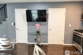 North Hollywood townhouse for rent - A kitchen with a glass table and a TV mounted on the wall.