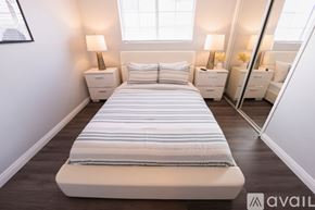Cypress house for rent - A bedroom with a large bed and two nightstands with lamps.