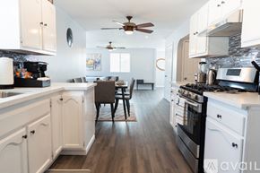 Cypress house for rent - A kitchen with white cabinets and a wooden floor.