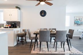 Cypress house for rent - A dining room with a table set for six and a fan on the ceiling.