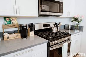 North Hollywood townhouse for rent - A kitchen with a black stove top and white cabinets.