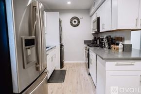 Los Angeles townhouse for rent - A kitchen with a stainless steel refrigerator and white cabinets.