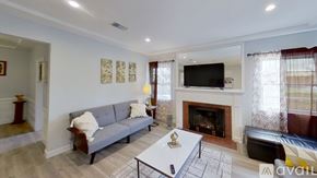 Los Angeles house for rent - A living room with a grey couch, a coffee table, and a fireplace.