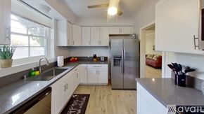 Los Angeles house for rent - A kitchen with white cabinets and a stainless steel refrigerator.