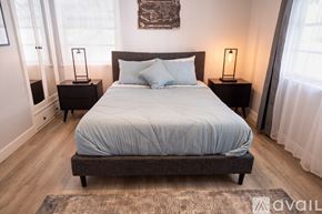 Los Angeles house for rent - A bedroom with a large bed and two nightstands with lamps.