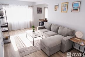 Los Angeles apartment for rent - A living room with a grey sofa, a glass table, and a small potted plant.