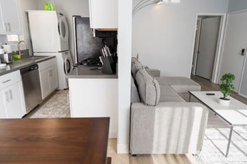 Los Angeles apartment for rent - A modern kitchen with a dining table and a grey couch in the living room.