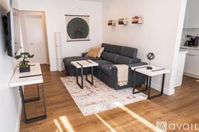 North Hollywood apartment for rent - A living room with a grey couch, a small table, and a plant.