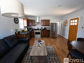 Los Angeles house for rent - A modern kitchen with a black couch and wooden floors.
