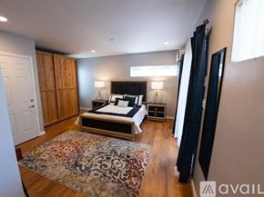 Los Angeles house for rent - A bedroom with a large bed and a rug on the floor.