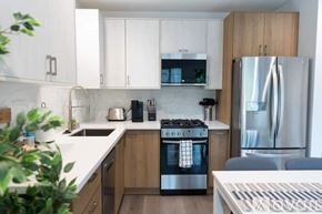 Los Angeles house for rent - A modern kitchen with a stainless steel refrigerator and wooden cabinets.