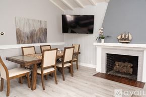 Los Angeles house for rent - A dining room with a fireplace and a painting on the wall.