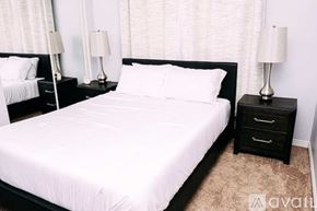 Los Angeles house for rent - A bedroom with a large bed and two nightstands with lamps.