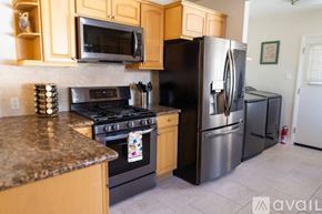 Los Angeles house for rent - A kitchen with a black refrigerator and stove.
