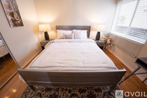 Los Angeles house for rent - A bedroom with a large bed and two lamps on either side of the bed.