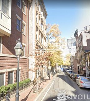 Boston apartment for rent - A street view of a residential area with parked cars and apartment buildings.