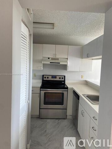 West Palm Beach condo for rent - A kitchen with a stove top oven and a sink.