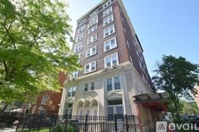 Chicago apartment for rent - A tall building with a red fence in front of it.
