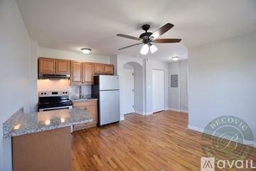 Chicago apartment for rent - A kitchen with wooden cabinets and a white refrigerator is available for rent.