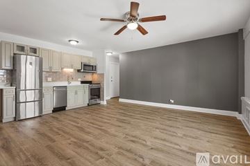 Chicago apartment for rent - A kitchen with a refrigerator, microwave, oven, and a fan on the ceiling.