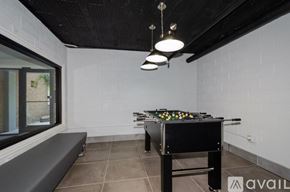 Chicago apartment for rent - A pool table is in the middle of a room with a bench and a window.