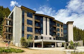 Winter Park condo for rent - A modern concrete building with a balcony and a carport.