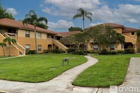 West Palm Beach condo for rent - A grassy area in front of apartment buildings.