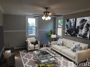 Monongahela house for rent - A living room with a white couch, a glass coffee table, and a ceiling fan.