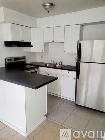 Ocala apartment for rent - A kitchen with white cabinets and a black countertop.