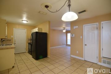 Copperas Cove house for rent - A kitchen area with a black refrigerator and cabinets.