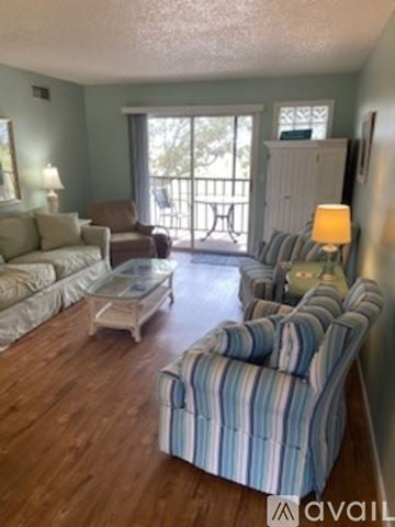 Venice condo for rent - A living room with a striped couch and a glass coffee table.