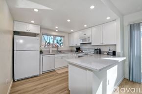 Carlsbad apartment for rent - A modern kitchen with white cabinets and appliances.