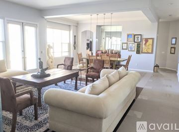 Chula Vista house for rent - A living room with a white couch and wooden chairs.