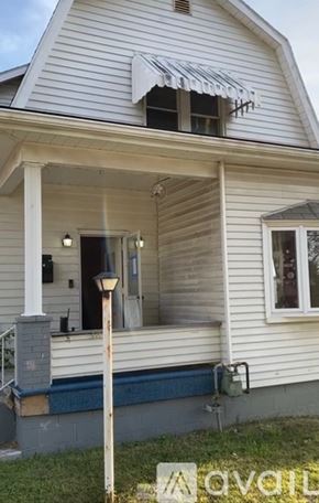 Belle Vernon house for rent - A white house with a porch and a lamp post.