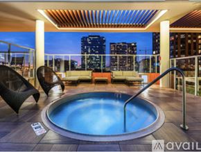 Chicago apartment for rent - A hot tub on a balcony with a city view at dusk.
