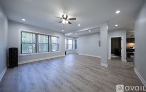 Chicago apartment for rent - A spacious room with a ceiling fan and wooden flooring.