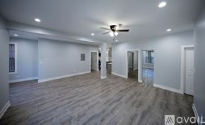 Chicago apartment for rent - A spacious room with wooden flooring and a ceiling fan.