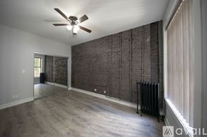 Chicago apartment for rent - A room with a ceiling fan and a brick wall.
