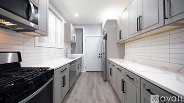 Chicago apartment for rent - A modern kitchen with a black stove top and white tiled backsplash.