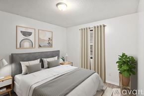 Yorktown apartment for rent - A bedroom with a large bed, a potted plant, and two framed pictures on the wall.