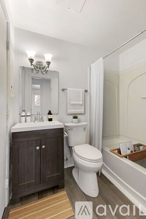 Yorktown apartment for rent - A bathroom with a toilet, sink, and mirror.