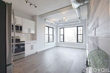 Chicago apartment for rent - A spacious kitchen with white cabinets and a stainless steel refrigerator.